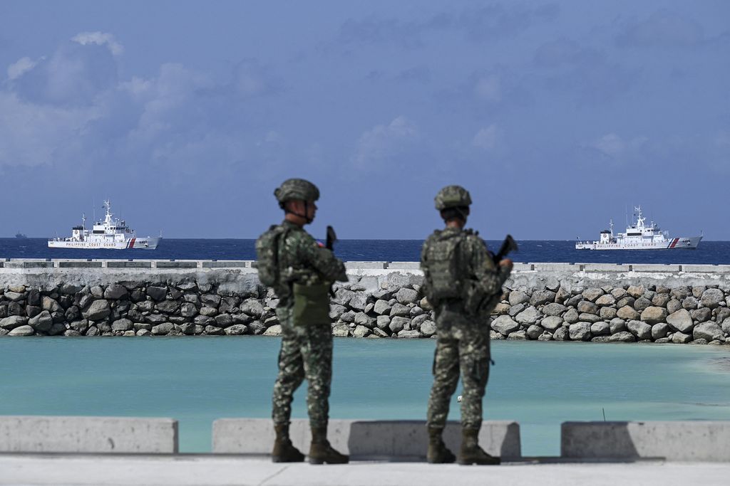 Tentara Filipina mengamati kapal penjaga pantai Filipina di dekat Pulau Thitu di Laut China Selatan yang disengketakan, Jumat (1/12/2023). 