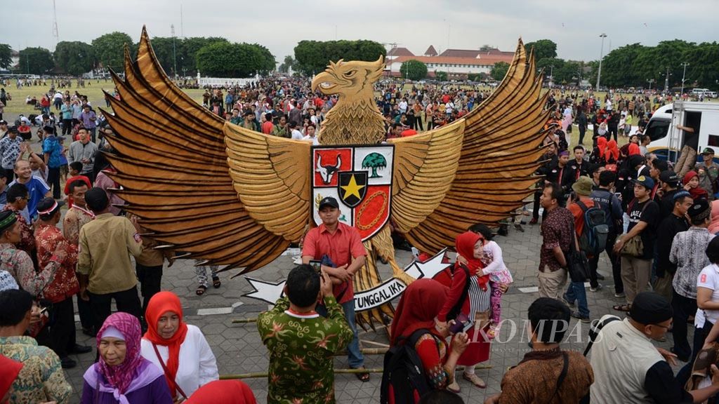 Warga berfoto dengan latar belakang lambang Burung Garuda saat mengikuti acara peringatan Hari Lahir Pancasila di Alun-alun Utara, Yogyakarta, Kamis (1/6/2017). 