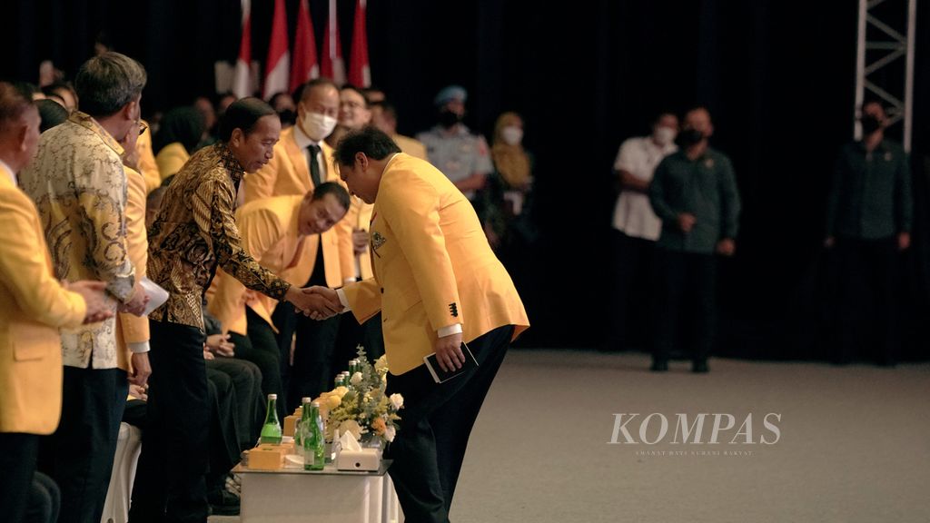 Ketua Umum Partai Golkar Airlangga Hartarto (kanan) menyalami Presiden Joko Widodo dalam acara puncak peringatan Hari Ulang Tahun Ke-58 Partai Golkar di JIExpo Kemayoran, Jakarta, Jumat (21/10/2022). 