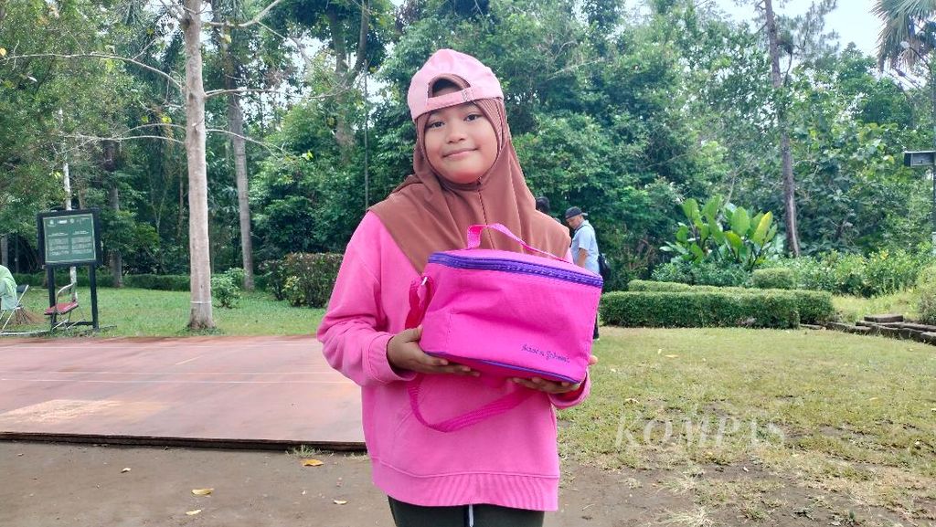 Meisya (12), a child, a visitor from Semarang, shows off the hampers she received from President Joko Widodo's entourage who came to visit Borobudur Temple, Saturday (25/5/2024).