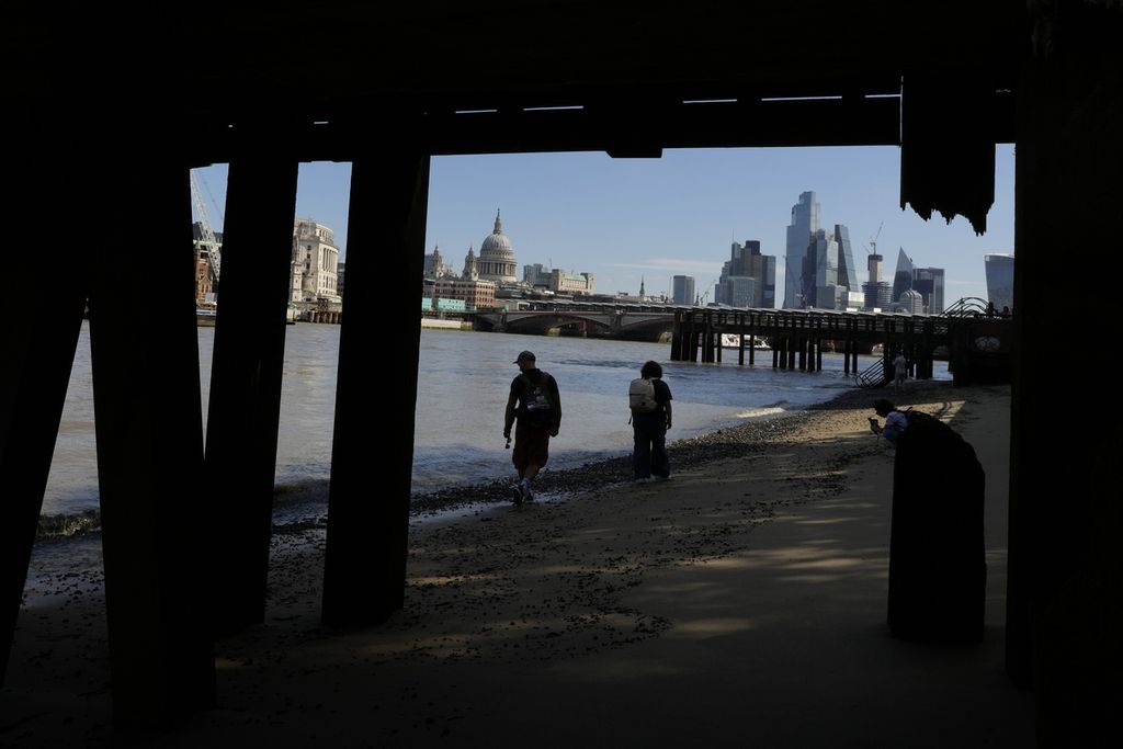 Warga berjalan-jalan di tepi Sungai Thames, London. Foto diambil pada Kamis (10/8/2023).