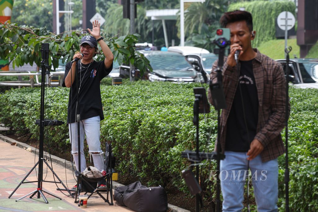 Sejumlah pembuat konten mengamen dengan melakukan siaran langsung di media sosial Tiktok di Kawasan Kuningan, Jakarta.