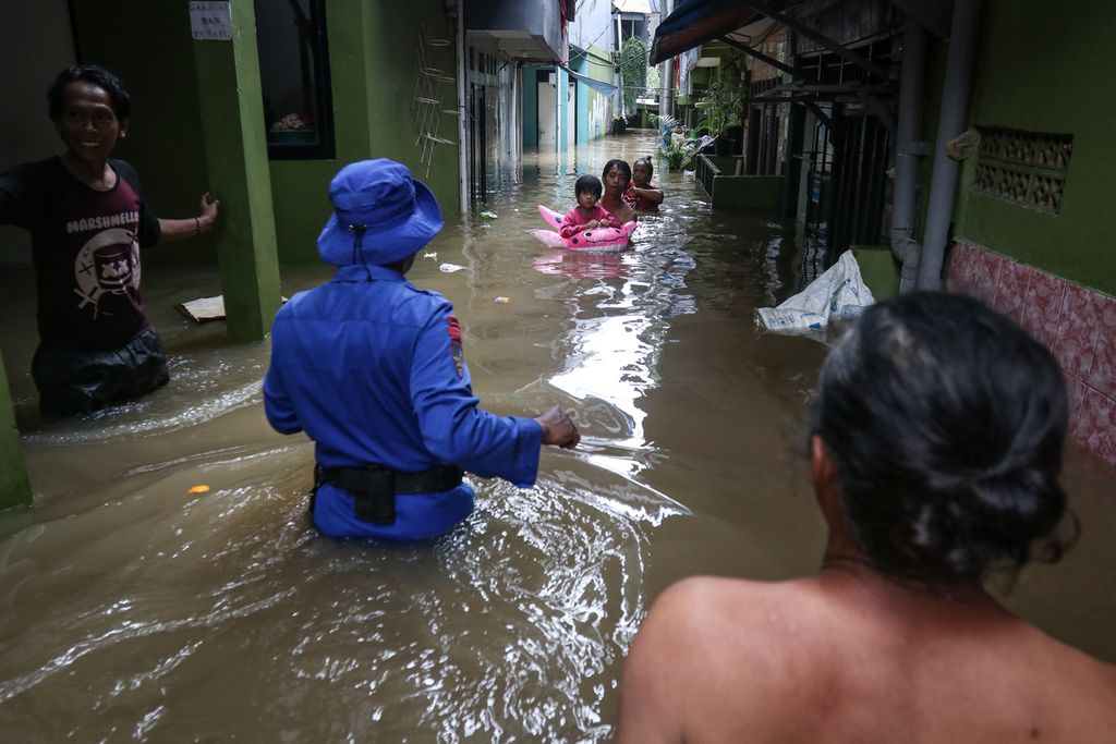 Petugas bersiap mengevakuasi warga saat banjir di Kampung Melayu, Jatinegara, Jakarta Timur, Senin (27/2/2023).  