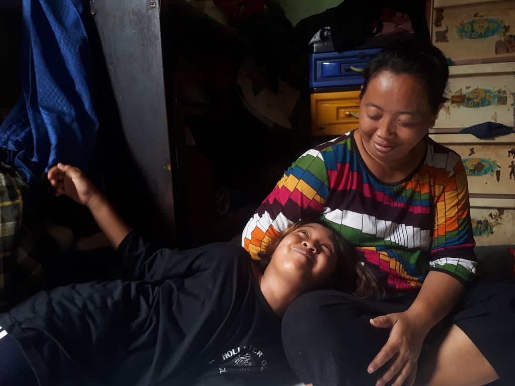 Trides (11) dan Marlina (47) sedang bergurau di ruang keluarga rumahnya di Cengkareng Timur, Cengkareng, Jakarta Barat, Senin (7/11/2022).