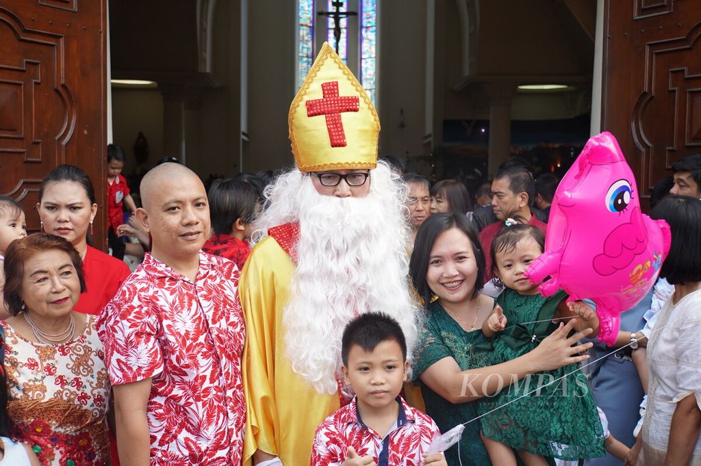 Umat berswafoto bersama maskot sinterklas selepas misa Natal, Rabu (25/12/2019), di Katedral Hati Tersuci Maria, Manado, Sulawesi Utara.