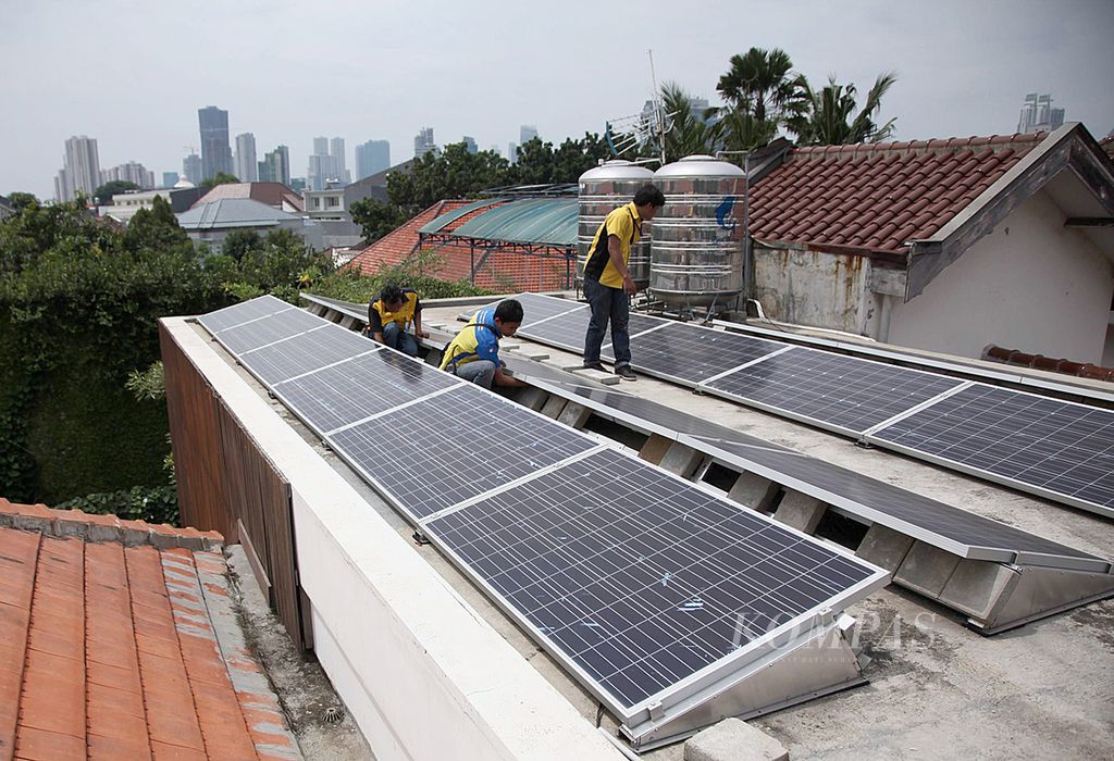 Petugas PLN memeriksa panel surya di rumah warga di kawasan Menteng, Jakarta Pusat, Senin (25/11/2013). 