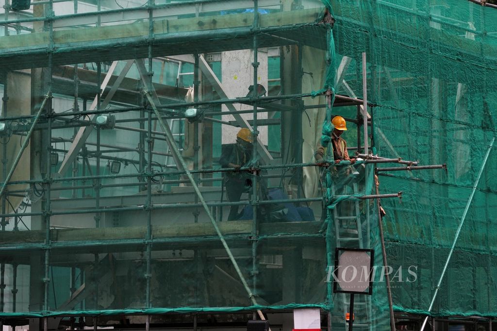 Pekerja keluar dari area proyek pembangunan jalur MRT di kawasan Jalan Thamrin, Jakarta, untuk beristirahat siang, Senin (20/12/2021).