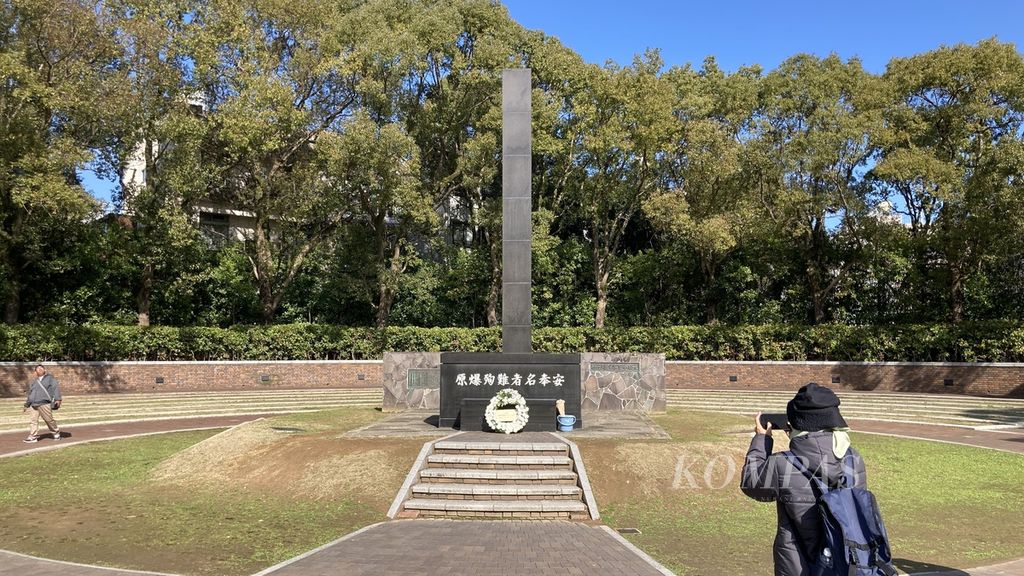Seorang wisatawan memotret tugu yang menjadi hiposentrum atau titik nol ledakan bom Nagasaki, Jumat (26/1/2024), di Taman Perdamaian Nagasaki, Nagasaki, Jepang. Bom atom meledak di Nagasaki pada 9 Agustus 1945. Bom yang dijatuhkan Amerika Serikat itu menyebabkan 73.884 korban tewas dan 74.909 orang terluka.