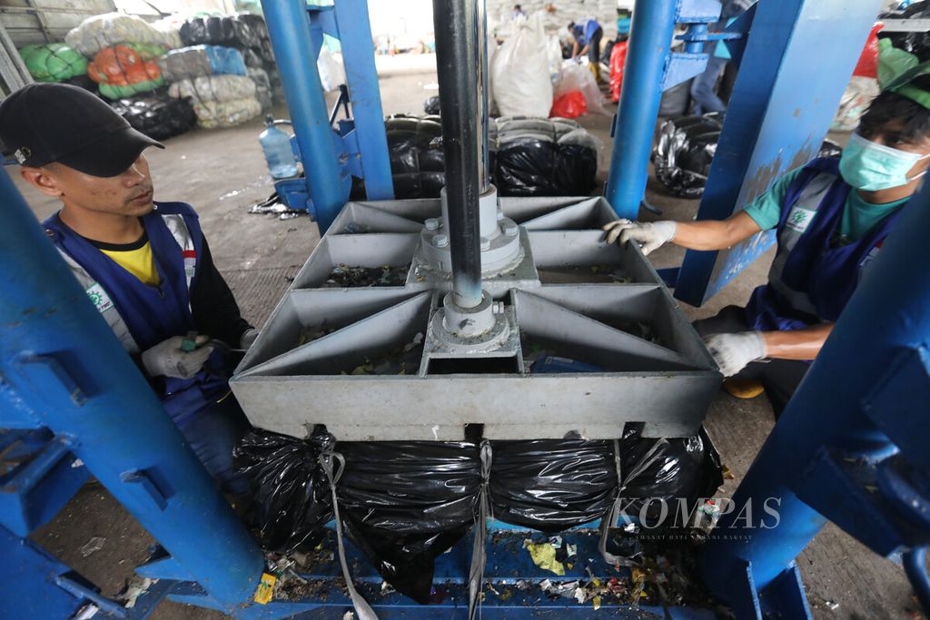 Pekerja mengemas sampah plastik yang telah dipres di penyedia jasa pengolahan sampah Rumah Pemulihan Material (RPM) Waste4Change Bekasi 2.0 di kawasan Padurenan, Mustika Jaya, Bekasi, Jawa Barat, Rabu (8/3/2023). 