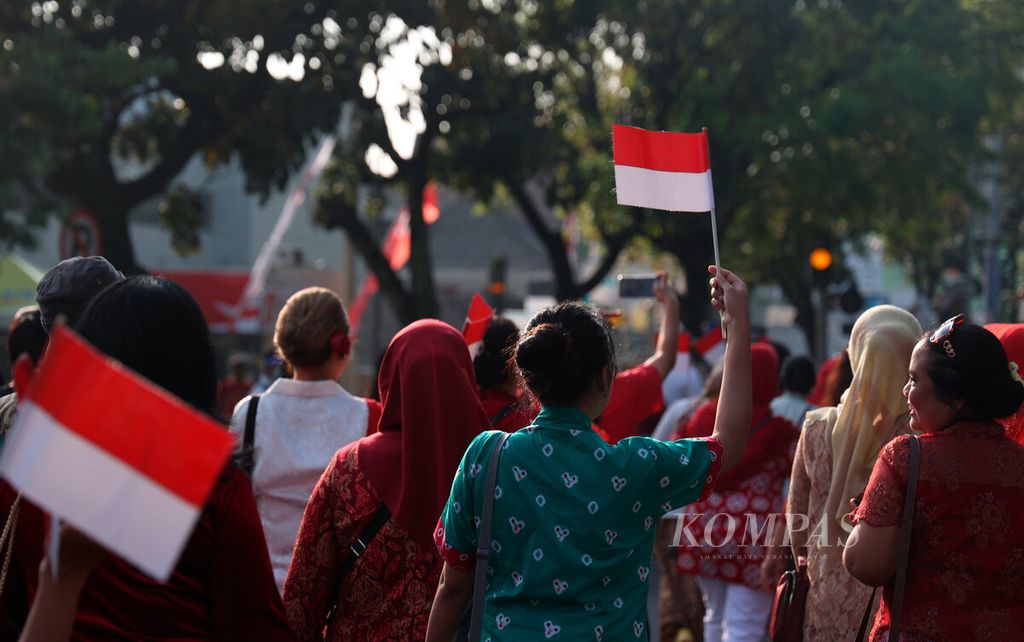 Perempuan dari berbagai komunitas berjalan mengenakan kebaya untuk memeriahkan HUT Ke-77 RI  di Loji Gandrung, Kota Surakarta, Jawa Tengah, Minggu (14/8/2022). Mereka mengenalkan kebaya sebagai bagian dari tren mode yang berkiblat pada warisan budaya.