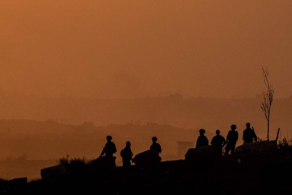 Dalam foto yang diambil pada Selasa (31/10/2023) di sekitara Sderot, Jalur Gaza, tampak siluet tentara Israel tengah melihat ke arah wilayah Palestina dari atas perbukitan.