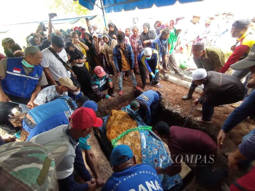Keluarga, petugas, dan beberapa anggota lembaga masyarakat membantu proses pemakaman Titi Wati (42), penderita obesitas, di Kota Palangkaraya, Kalimantan Tengah, Senin (30/1/2023).
