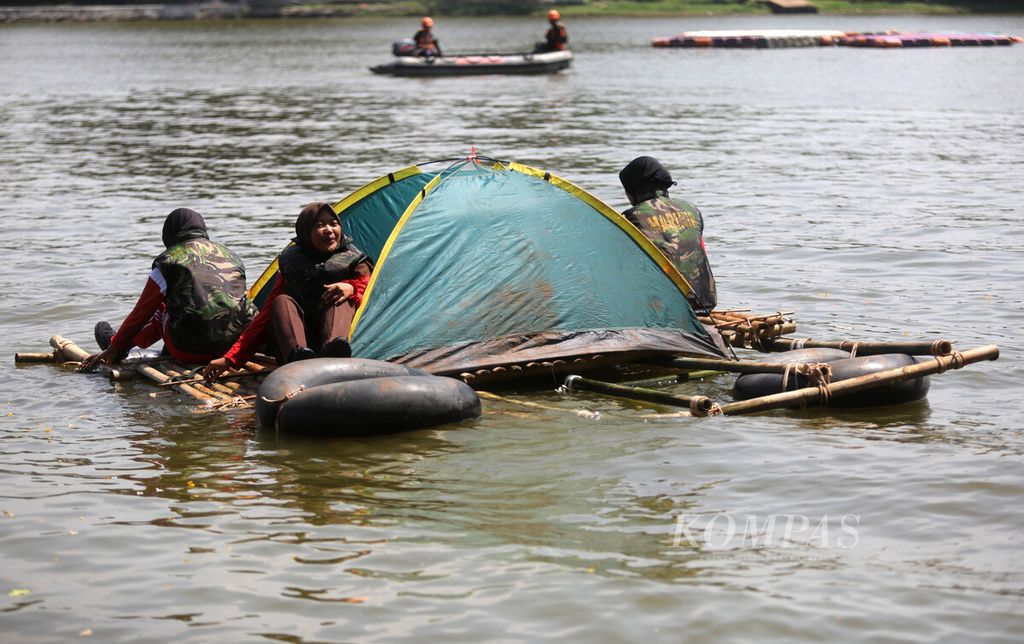 Peserta kontingen Jambore Nasional XI Gerakan Pramuka menaiki rakit saat menjalani pelatihan kondisi darurat di air danau Buperta, Cibubur, Jakarta, Jumat (19/8/2022). 