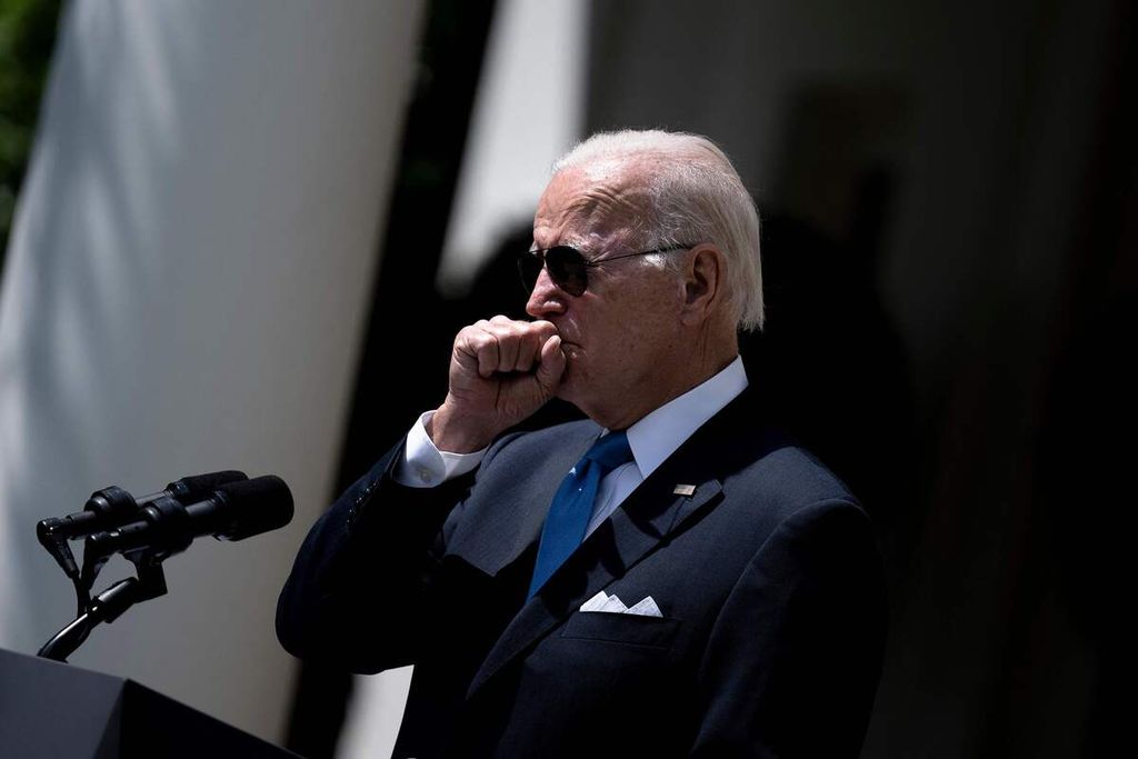 Presiden AS Joe Biden terbatuk saat berpidato di Taman Mawar Gedung Putih, Washington DC, AS, Rabu (27/7/2022). Tim dokter Gedung Putih, Sabtu (30/7), mengumumkan Biden kembali dinyatakan positif Covid-19.