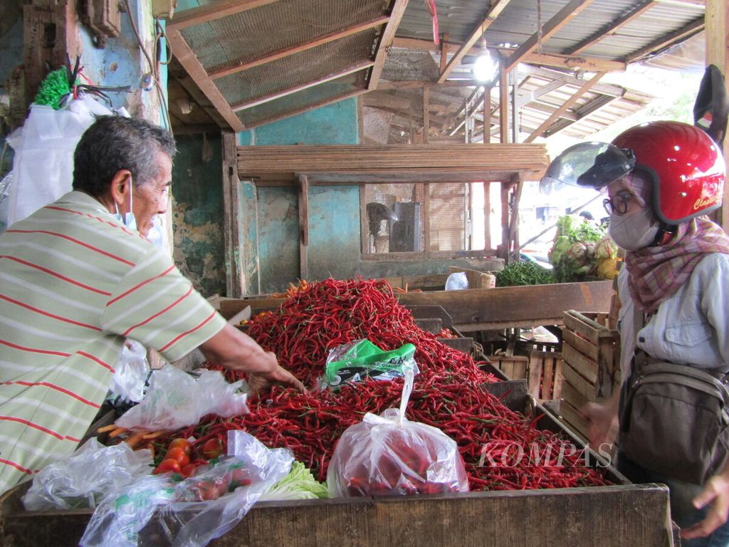 Seorang pedagang cabai melayani pembeli di Pasar Pasir Gintung, Bandar Lampung, Jumat (25/3/2022).