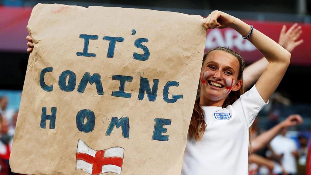Suporter Inggris membawa poster ”Sepak Bola Pulang ke Rumah” merayakan kemenangan Inggris atas Swedia pada perempat final Piala Dunia 2018 di Samara Arena, Rusia (7/7/2018).