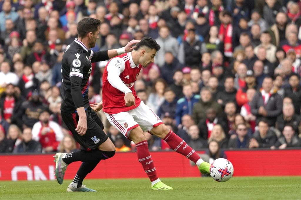 Pemain Arsenal, Gabriel Martinelli (kanan), melepas tendangan untuk mencetak gol ke gawang Crystal Palace pada laga Liga Inggris di Stadion Emirates, London, Minggu (19/3/2023) WIB. Pada laga itu, Arsenal menang dengan skor 4-1. 