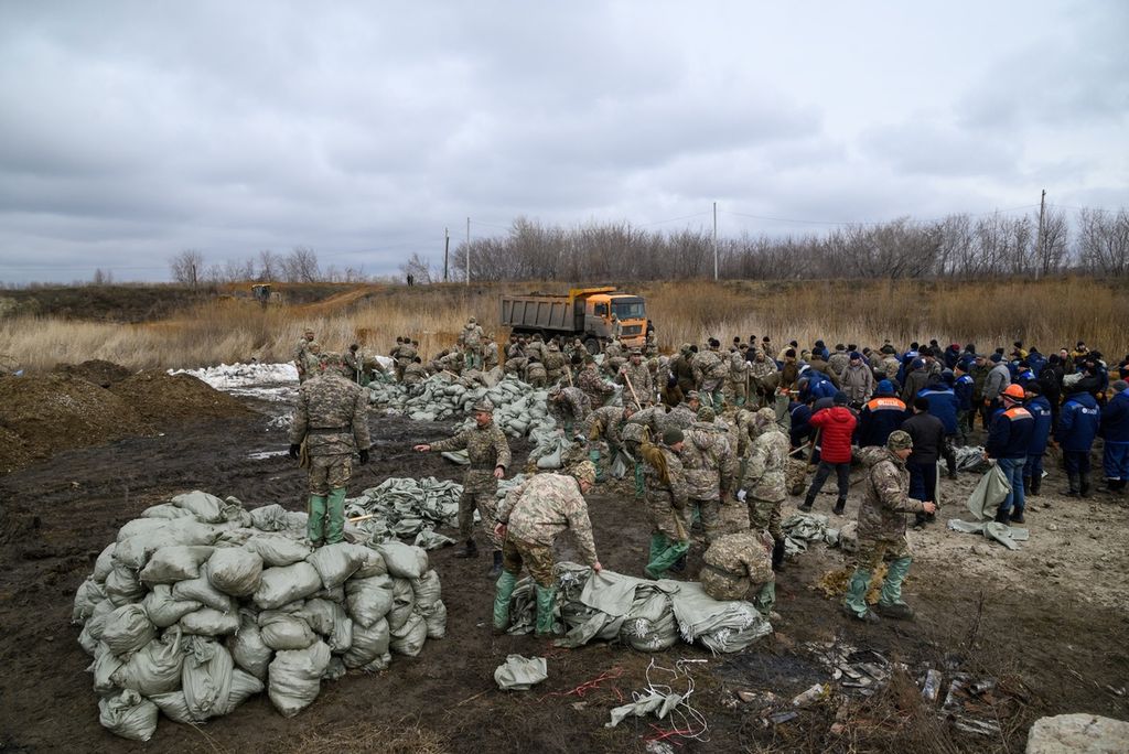 Pekerja dan tentara membangun tanggul darurat untuk mengantisipasi meluasnya dampak banjir di kawasan permukiman Zarechny di kota Petropavl, Kazakhstan, yang berbatasan dengan Rusia, Rabu (10/4/2024). Balapan MotoGP seri Kazakhstan musim 2024 resmi dibatalkan karena kesulitan pengiriman logistik balapan sebagai dampak banjir.