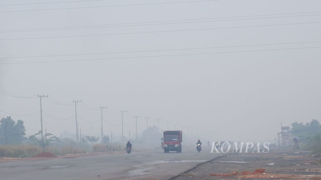 Jalan Gubernur Syarkawi di Kecamatan Gambut, Kabupaten Banjar, Kalimantan Selatan, diselimuti kabut asap, Selasa (18/9/2018), sekitar pukul 08.00 Wita. 