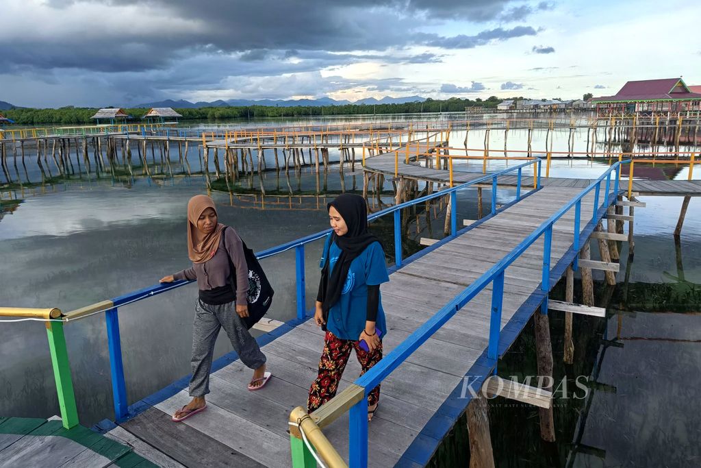 Indriani Usman (right), with her partner while walking along Alo Cinta, a location to see sunrise and sunset views, in Torosiaje Village, Popayato, Pohuwato Regency, Gorontalo, Saturday (16/7/2022). Indri is one of the women in the Bajo Torosiaje tribe who completed her education until she graduated from college.
