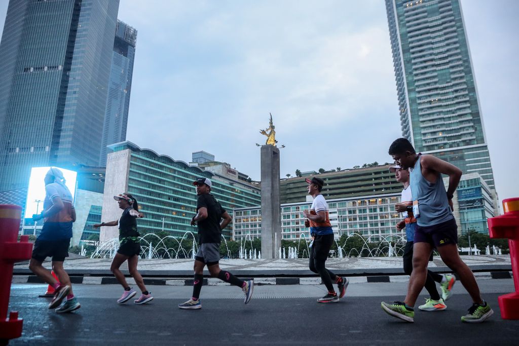 Para peserta LPS Monas Half Marathon berlari di kawasan bundaran Hotel Indonesia (HI), Jakarta, Minggu (2/7/2023). 