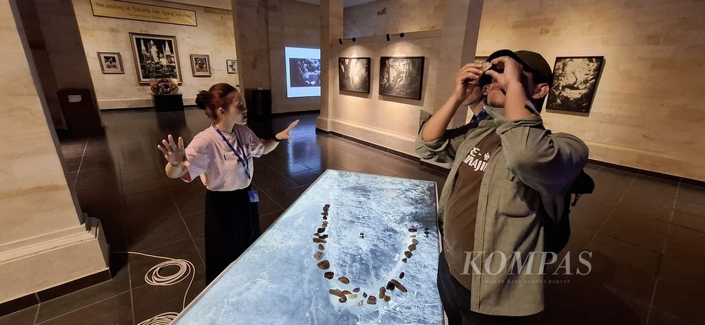 Pengunjung melihat batu dengan kaca pembesar yang merupakan bagian dari karya perupa Yudha Kusuma Putera berjudul &quot;Simulasi Lanskap Kali Oya&quot; 