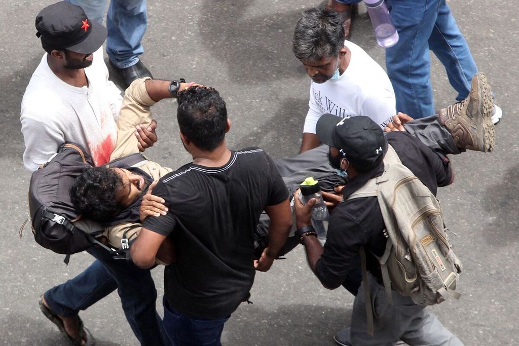 Pengunjuk rasa menggotong pria terluka dalam demonstrasi guna menuntut pengunduran diri Presiden Sri Lanka Gotabaya Rajapaksa di Colombo, Sri Lanka, Sabtu (9/7/2022). 