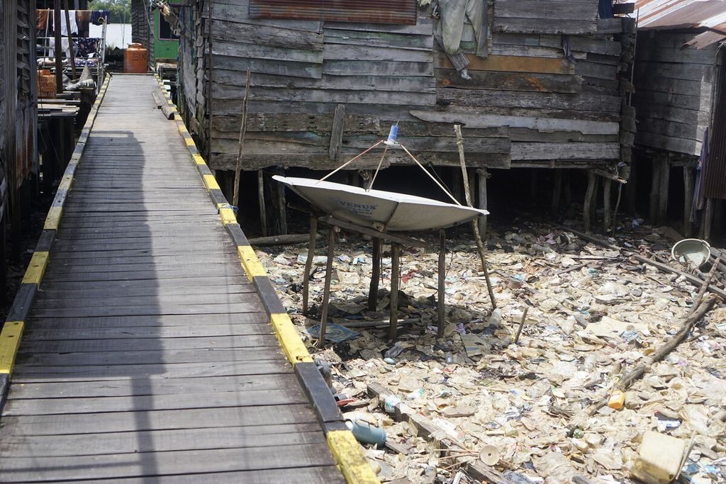 Sampah plastik berceceran di sekitar rumah panggung warga di Desa Muara Adang, Kecamatan Long Ikis, Kabupaten Paser, Kalimantan Timur, Kamis (15/2/2023).