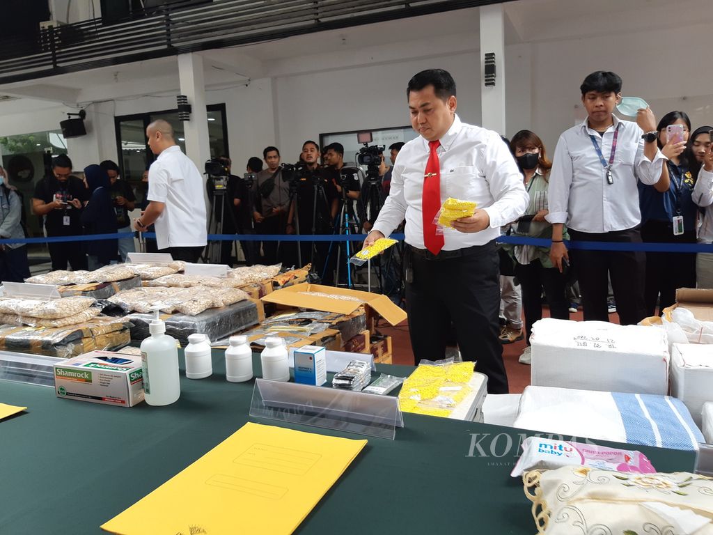 Petugas menyiapkan barang bukti berupa pil PCC dan obat-obatan daftar G yang ditemukan di salah satu rumah toko di Kabupaten Tangerang, Banten, dan Kota Bekasi, Jawa Barat, untuk dipaparkan kepada wartawan, Senin (10/4/2023), di Polda Metro Jaya, Jakarta.