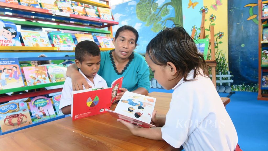 Guru mendampingi siswa membaca di perpustakaan sekolah pada Selasa (27/9/2022). Sebanyak 56 SD di Kabupaten Nagakeo, Nusa Tenggara Timur, mendapatkan dukungan untuk memiliki perpustakaan sekolah ramah anak dari Taman Bacaan Pelangi dan Room To Read. 
