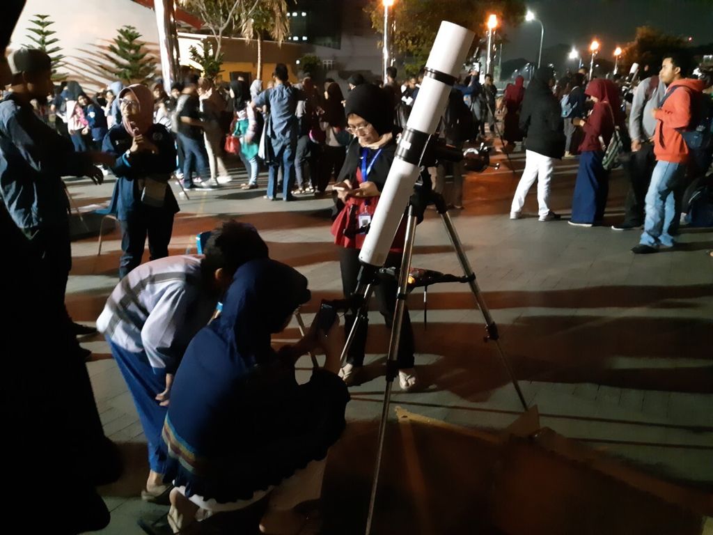 Pengunjung menggunakan teleskop untuk melihat bulan di Pelataran Plaza Teater Jakarta, Taman Ismail Marzuki, Jakarta, Jumat (27/7/2018).
