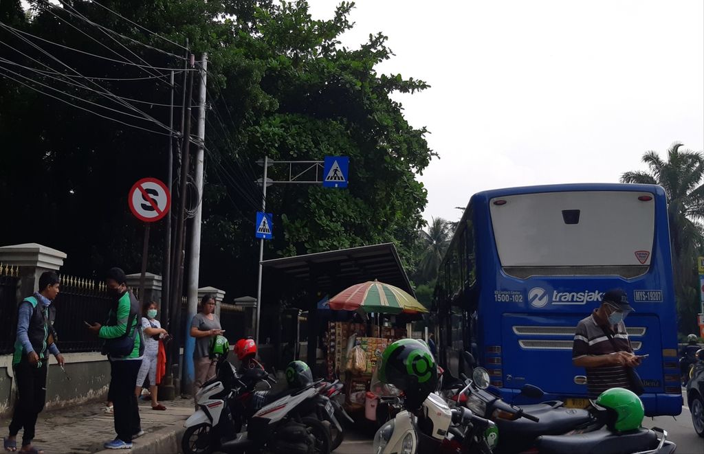 Sejumlah warga tidak mengenakan masker di sekitar halte Transjakarta Cibubur, Jakarta Timur, Senin (25/1/2021).