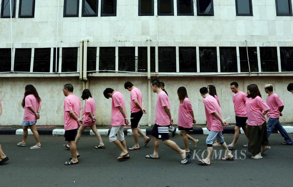 Tersangka kasus penipuan melalui telepon (phone fraud)  dibawa ke sel tahanan  di Polda Metro Jaya, Jakarta, Senin (31/7).  Polri bersama kepolisian China menangkap  153 orang (149 di antaranya warga negara  China) pelaku penipuan melalui telepon di Jakarta, Surabaya, Batam, dan Bali.