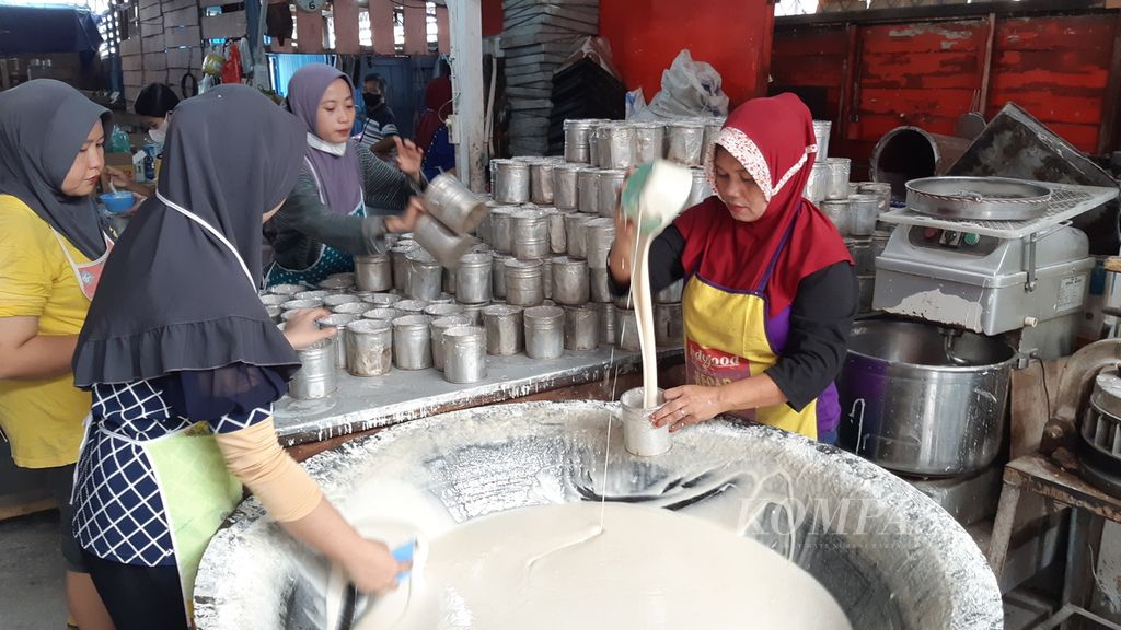 Pekerja sedang menuang adonan kue keranjang atau kue tutun ke loyang di sebuah industri rumahan Kota Bandar Lampung, Lampung, Senin (16/1/2023). Jelang Imlek, pedagang kue keranjang di Bandar Lampung mendapat banyak pesanan kue keranjang. 