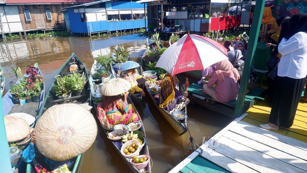Warga membeli buah di pasar terapung yang digelar di Dermaga Desa Wisata Kubah Basirih di Kota Banjarmasin, Kalimantan Selatan, Jumat (3/6/2022).