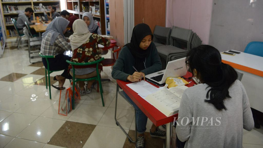 Mahasiswa mengerjakan tugas kuliah di Perpustakaan Kota Yogyakarta, Kotabaru, Yogyakarta, Jumat (5/7/2019).