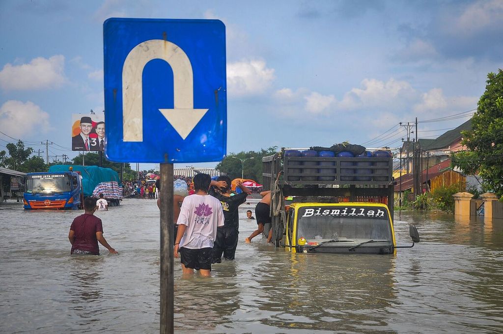 Sejumlah kendaraan mogok di jalan raya nasional yang terdampak banjir karena hujan deras dan meluapnya sungai di Demak, Jawa Tengah, Minggu (11/2/2024).