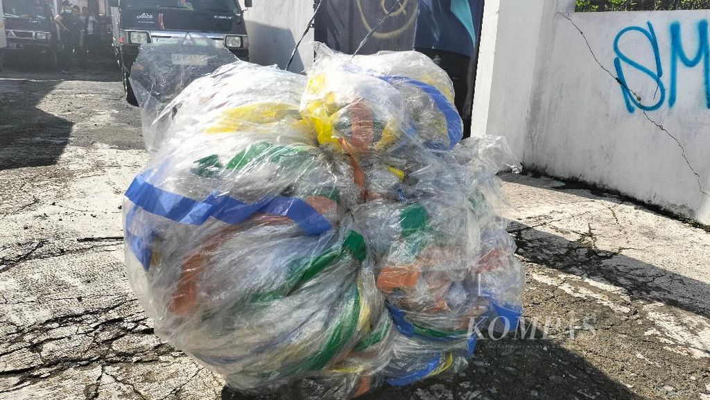 Balon udara yang telah jatuh di gudang dan kantor distributor es krim di Jalan Urip Sumoharjo, Kota Magelang, digulung oleh pegawai setempat,  Sabtu (13/4/2024).