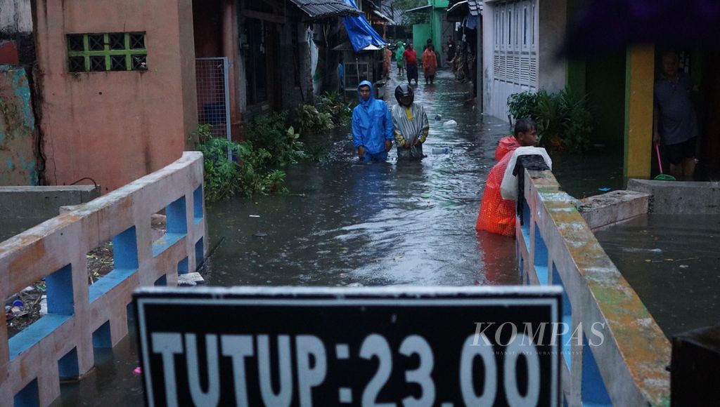Warga menggotong barang berharganya sewaktu terjadi banjir di Kelurahan Jagalan, Kecamatan Jebres, Kota Surakarta, Jawa Tengah, Kamis (16/2/2023). Banjir terjadi akibat hujan deras berjam-jam. 