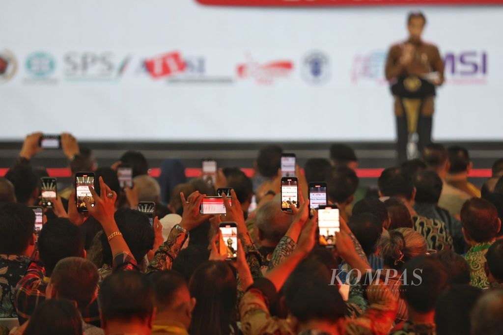 Wartawan mengabadikan Presiden Joko Widodo saat memberikan sambutan pada puncak peringatan Hari Pers Nasional (HPN) 2024 di Ecovention Hall, Ancol, Jakarta, Selasa (20/2/2024). 