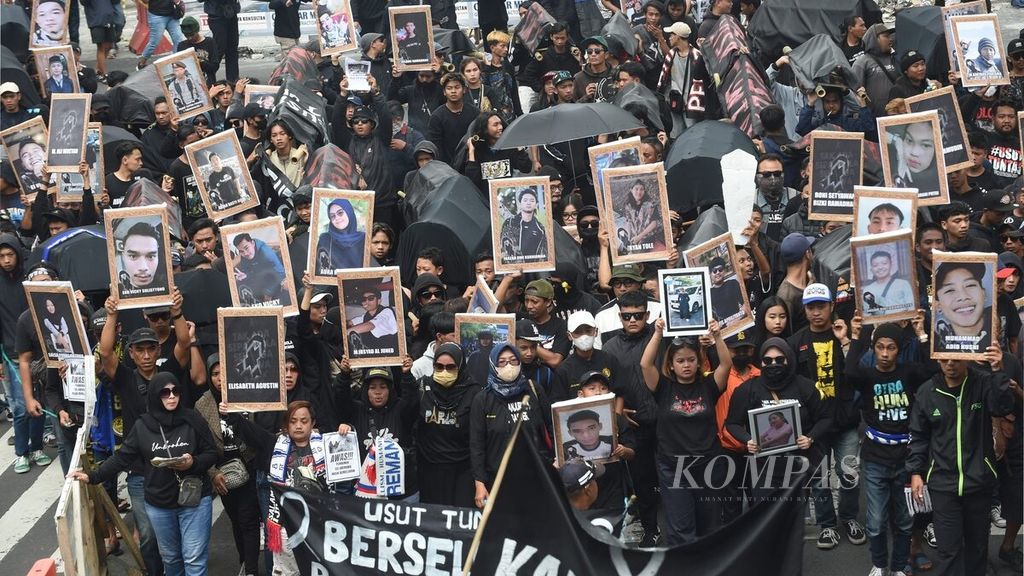 Protesters carry coffins and photos of the victims who died in the Kanjuruhan Tragedy during the "Malang Menghitam" demonstration in Malang City, East Java, on Thursday (10/11/2022). Aremania did a long march from Gajayana Stadium to Malang City Square. 