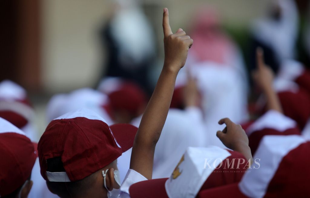  Seorang anak menunjukkan jarinya saat berkumpul di lapangan pada hari pertama sekolah tahun ajaran baru 2022/2023 di SDN 11 Pondok Bambu, Jakarta, Senin (11/7/2022). 