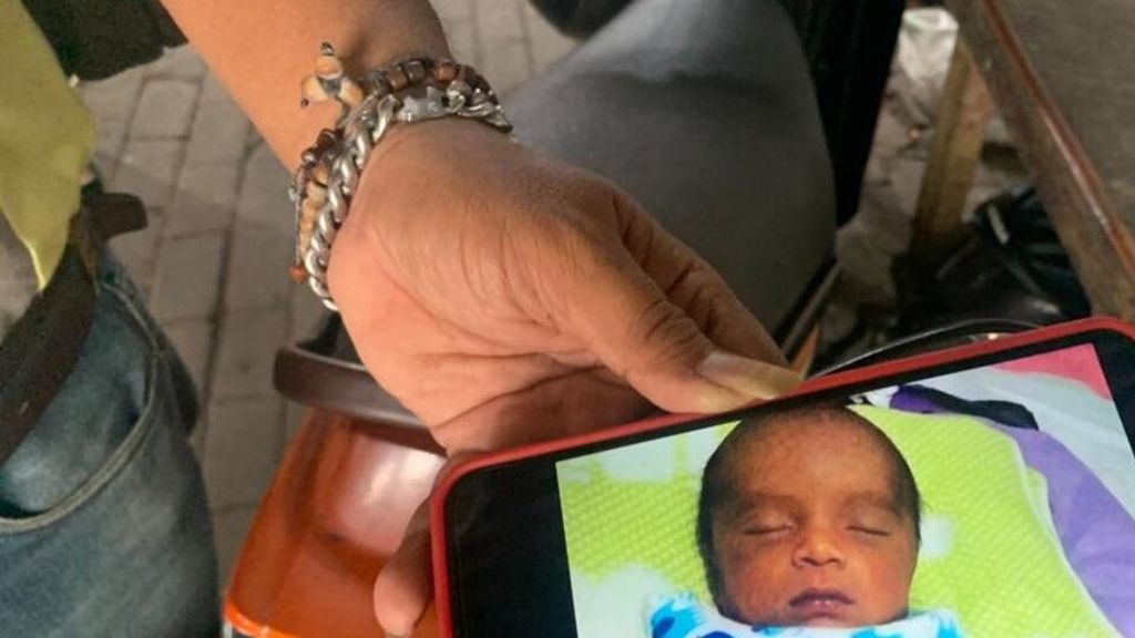 Al (50) menunjukkan foto bayi yang pernah ia rawat selama tiga bulan di Surabaya, Jawa Timur, Senin (27/3/2023), sebelum bayi itu diminta kembali ibu kandungnya.