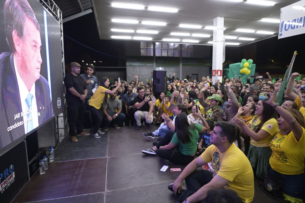 Pendukung Presiden Jair Bolsonaro menonton wawancaranya dengan televisi Rede Globo di layar lebar saat ia berkampanye untuk pemilihan kembali pada bulan Oktober di Belo Horizonte, Negara Bagian Minas Gerais, Brasil, Senin (22/8/2022).