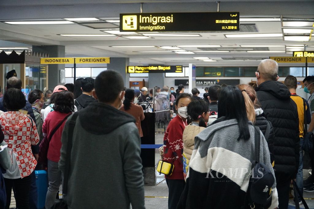 Wisatawan asal Kunming, China, mengantre di bagian imigrasi pintu kedatangan penumpang penerbangan internasional Bandara Internasional Minangkabau, Padang Pariaman, Sumatera Barat, Minggu (26/1/2020).
