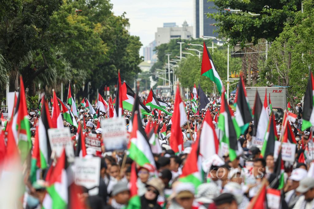 Pengunjuk rasa membawa bendera Palestina dan Indonesia di depan Kedutaan Besar Amerika Serikat, Jakarta, Sabtu (13/1/2024). Aksi ini untuk memperingati jelang 100 hari agresi Israel di Palestina. 