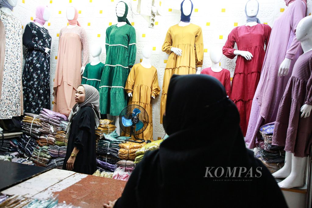 Pengunjung melihat pakaian muslim seragam untuk berlebaran yang ditawarkan di salah satu kios di Blok B Pasar Tanah Abang, Jakarta pusat, Rabu (20/4/2022).