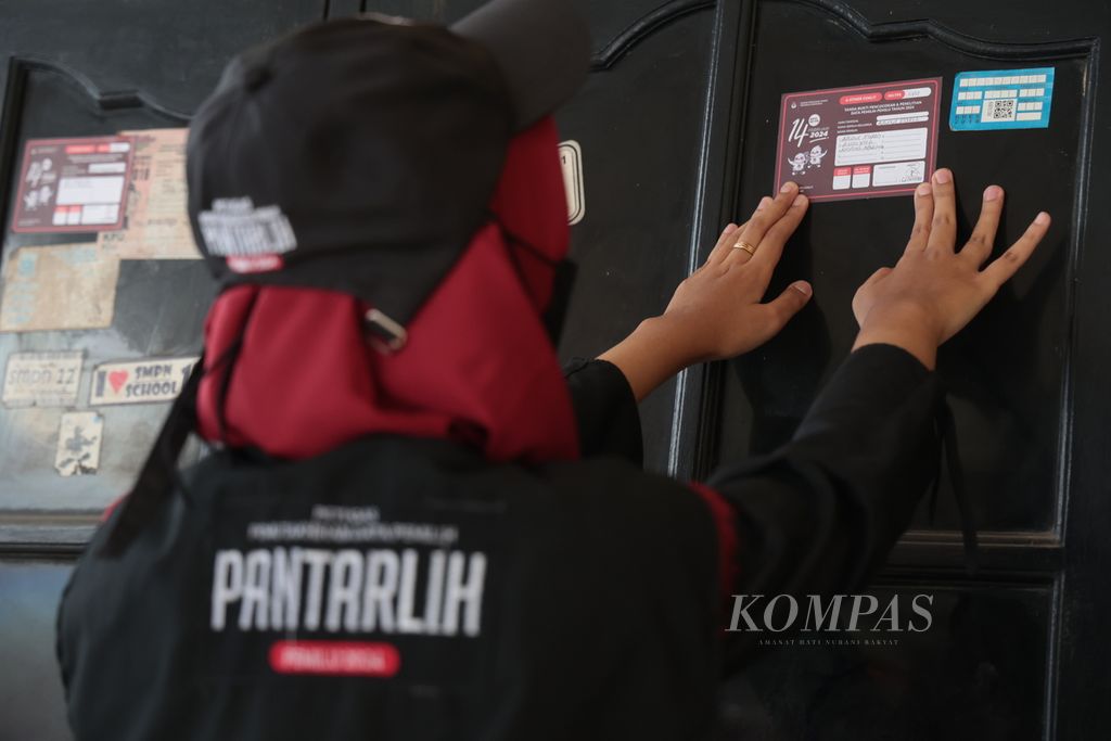 Petugas Pemutakhiran Data Pemilih (Pantarlih) menempelkan stiker sebagai tanda sudah dilakukan pencocokan dan penelitian (coklit) data Pemilu 2024 di RT 001 RW 002 Kelurahan Jurang Mangu Barat, Pondok Aren, Tangerang Selatan, Banten, Sabtu (5/3/2023). 