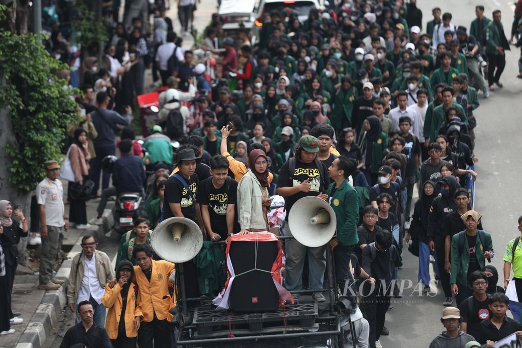 Demonstran melakukan aksi <i>long march</i> di Jalan Pemuda, Rawamangun, Jakarta, Rabu (28/2/2024). Sejumlah mahasiswa dan dosen dari Universitas Negeri Jakarta, beserta massa aksi yang tergabung dalam Gerakan Mahasiswa Bersama Rakyat (Gemarak), melakukan demonstrasi di depan Jalan Pemuda. 