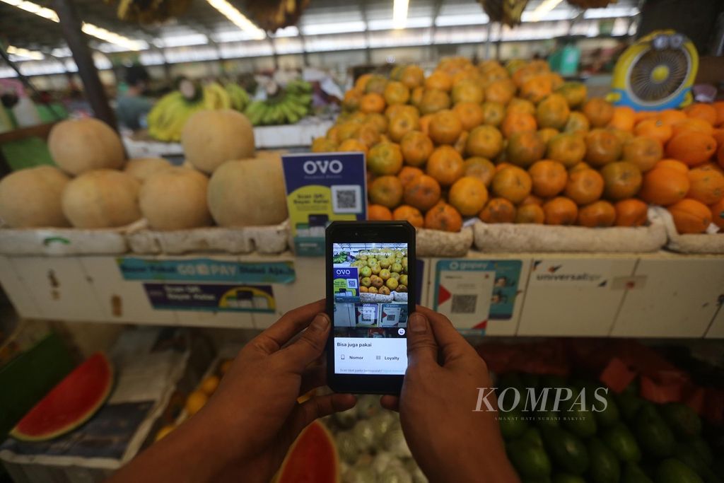Konsumen melakukan pembayaran dengan menggunakan uang elektronik yang disediakan oleh pedagang di Pasar Modern Bintaro, Tangerang Selatan, Senin (26/10/2020). Dari survei yang dilakukan oleh Otoritas Jasa Keuangan, akses terhadap produk dan layanan jasa keuangan atau inklusi keuangan meningkat 8,33 persen, dari 67,8 persen pada 2016 menjadi 76,19 persen pada 2019. 